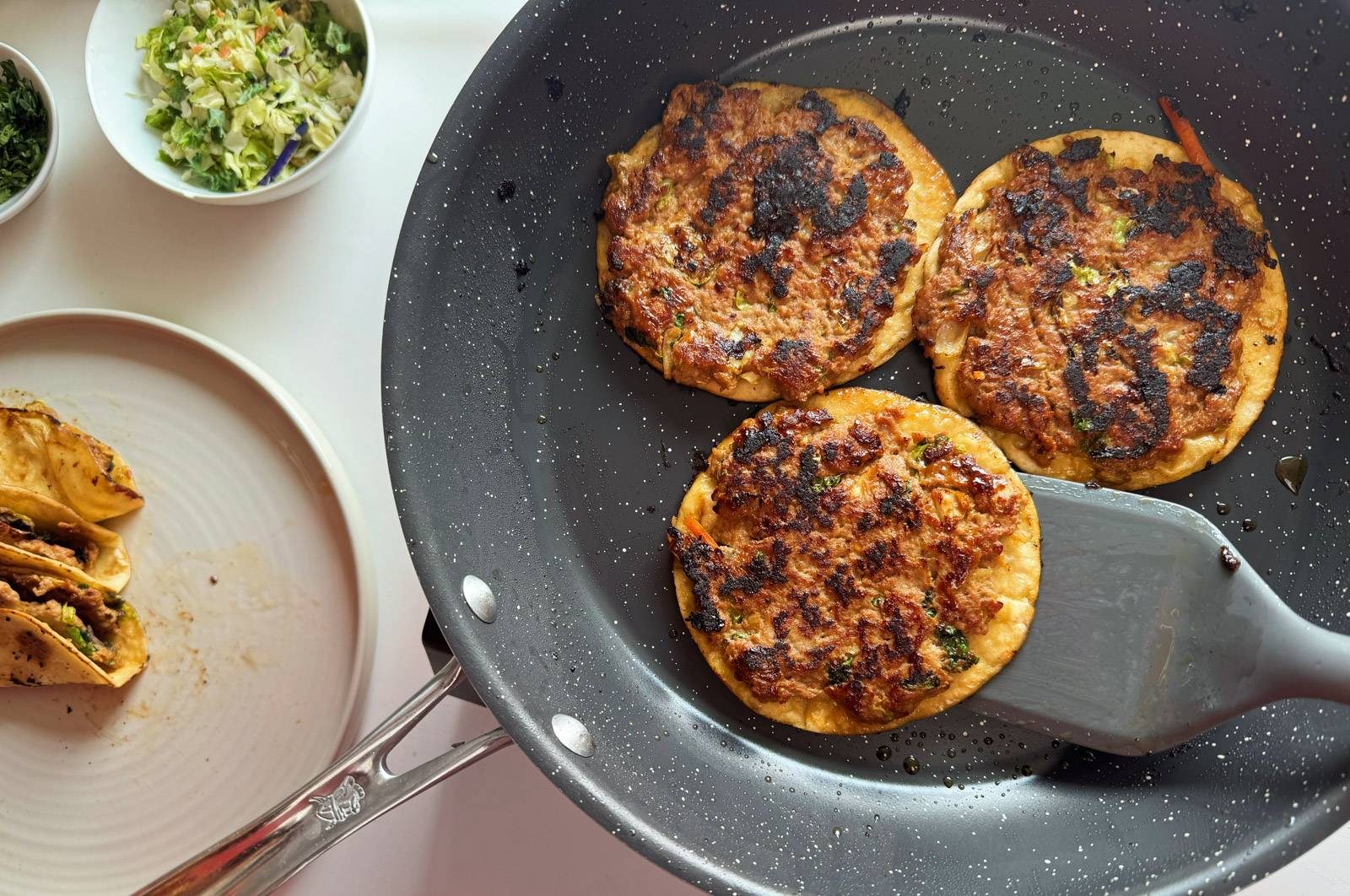 Frying egg roll tacos in a skillet.