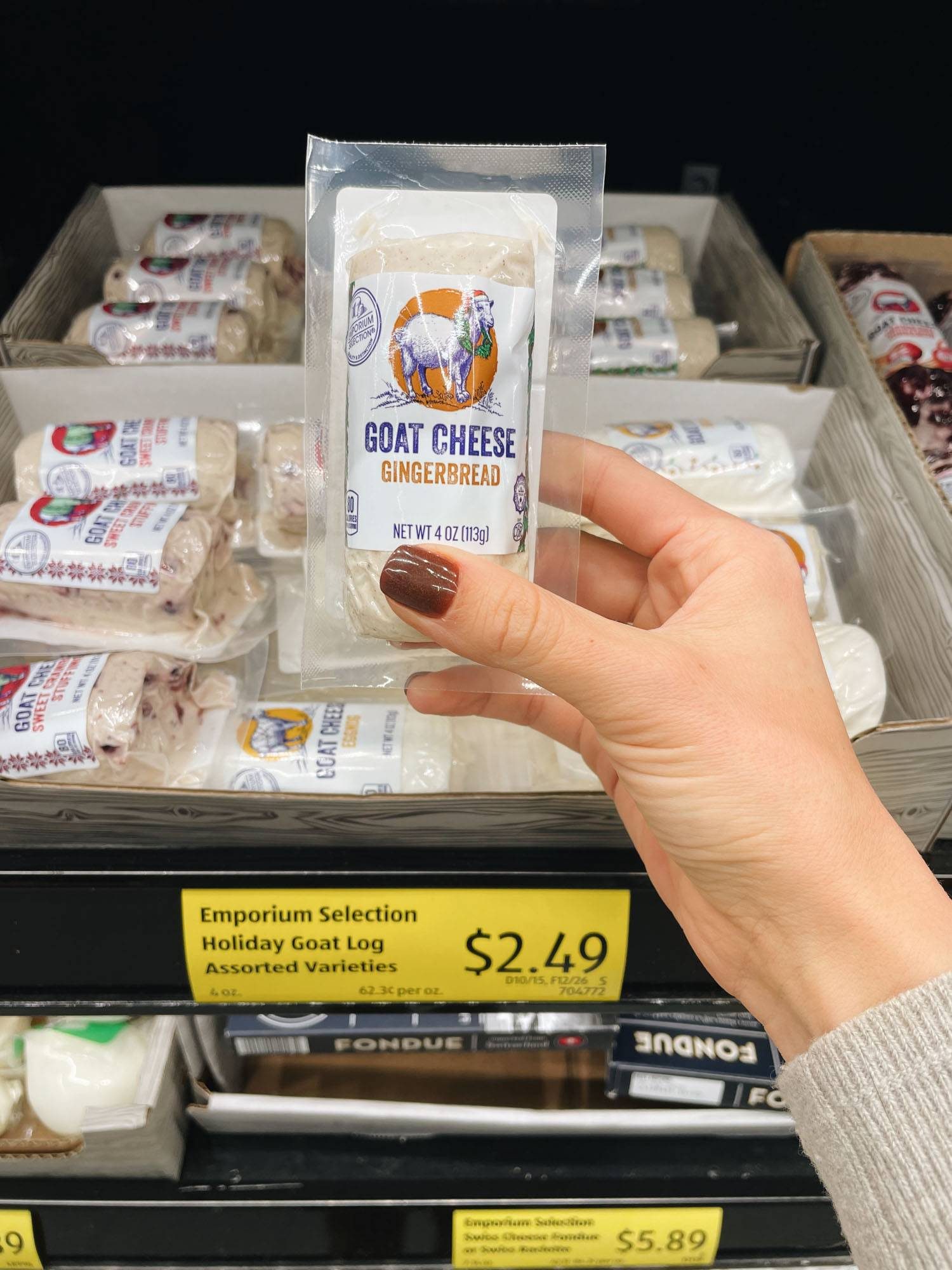 White hand holding roll of goat cheese