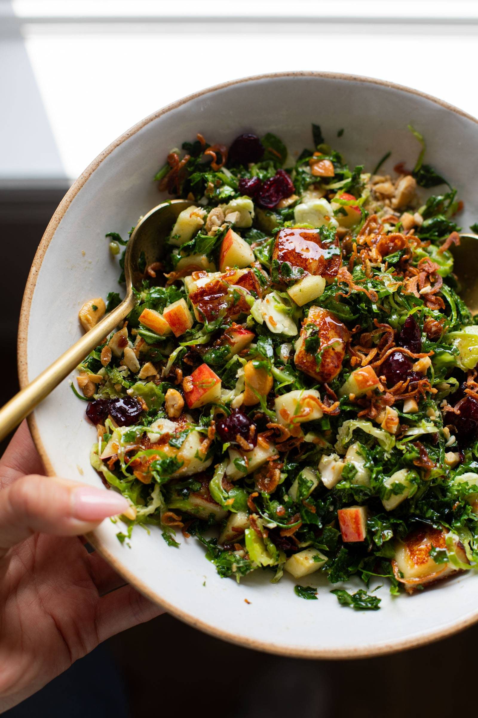 Kale apple salad in a bowl with crispy shallots.