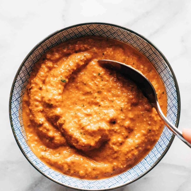 Romesco sauce in a bowl with a spoon.