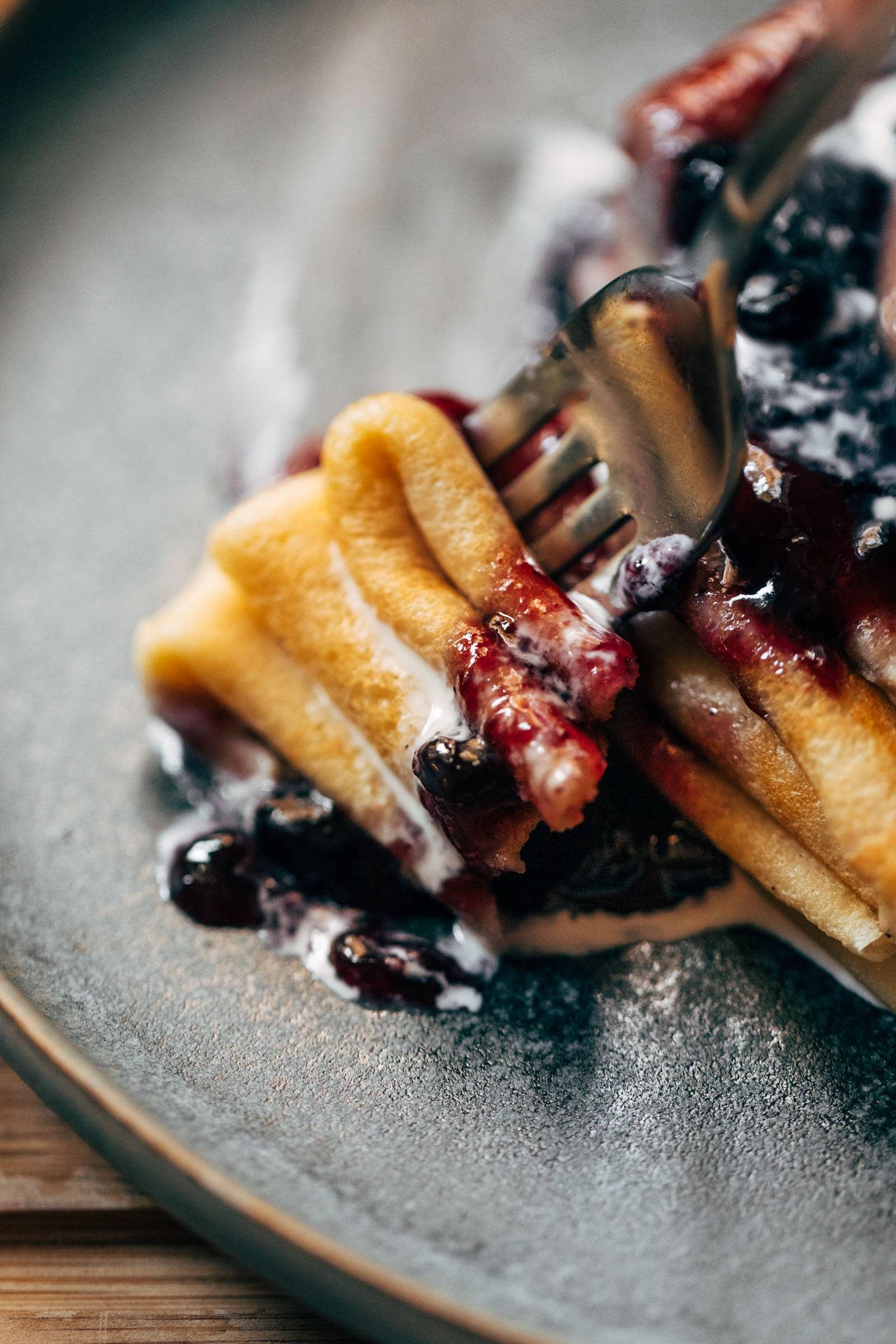 Fork taking a bite of Swedish pancakes.