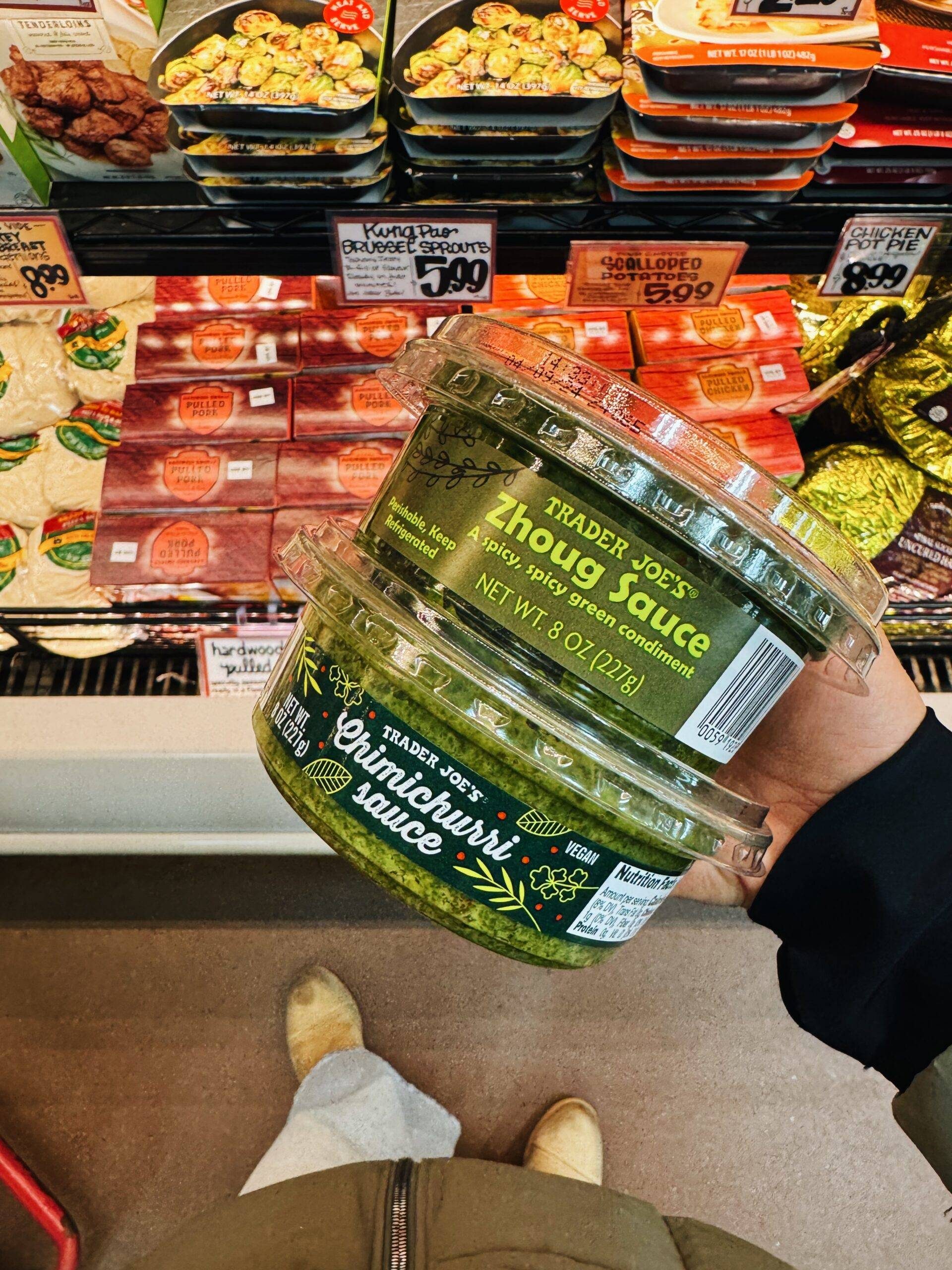 Containers of zhoug and chimichurri sauce.