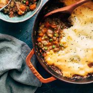 Meatless shepherd's pie being spooned out of a red pot.