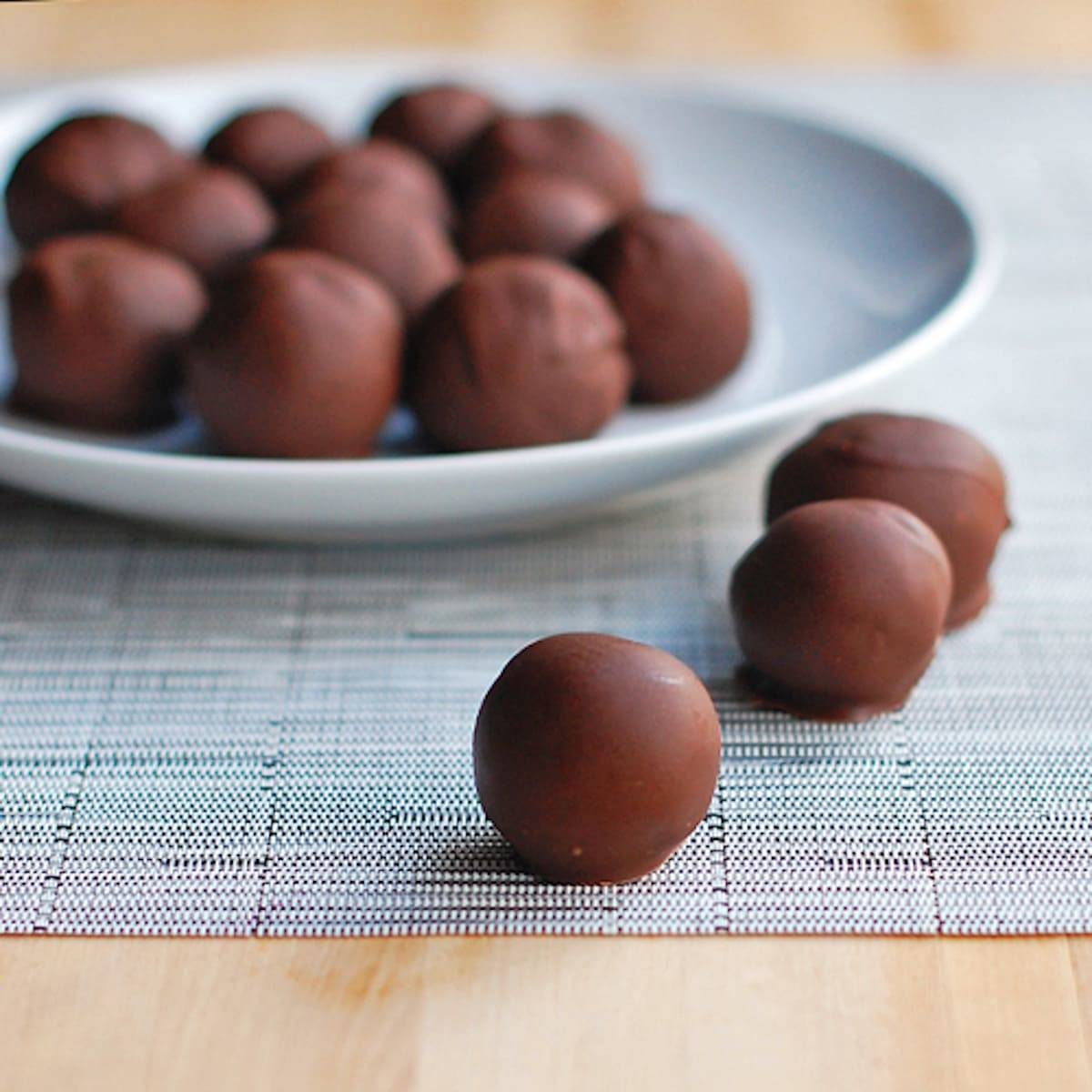 Triple chocolate party balls on a plate and a placemat.