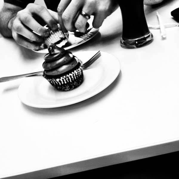 Black and white photo of a cupcake on a plate.