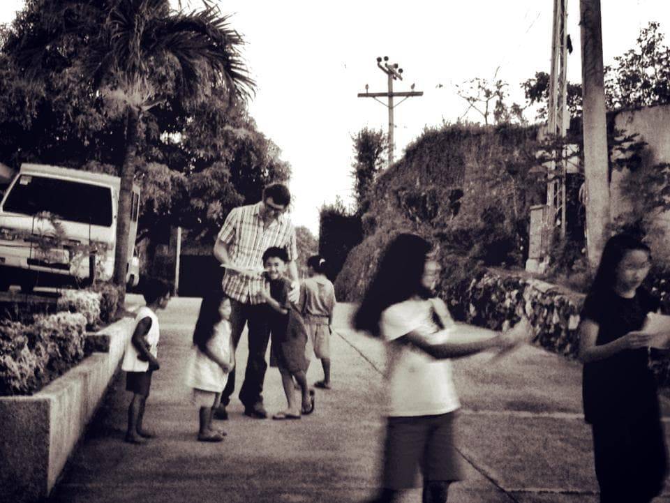Man hugging children on the street.