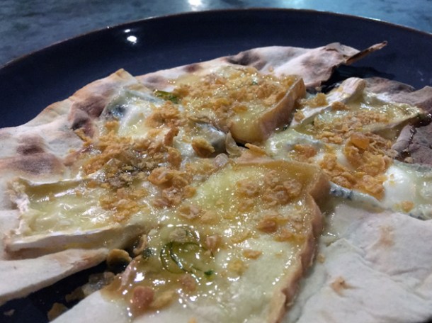 baked cheeses with nuts and honey on flatbread at temper