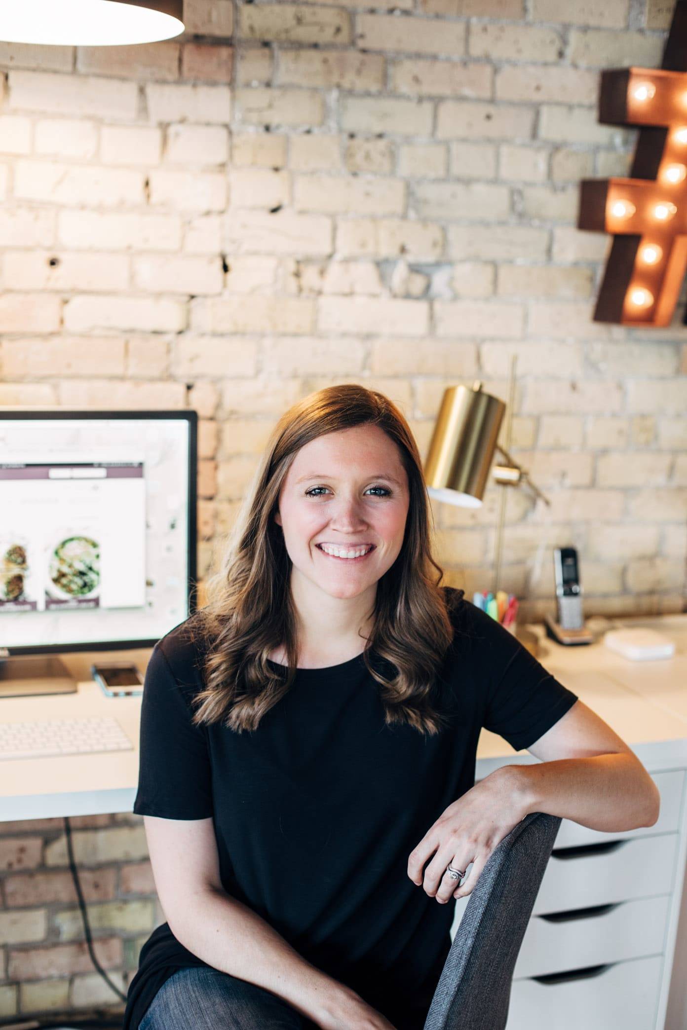 Woman sitting in a chair smiling.